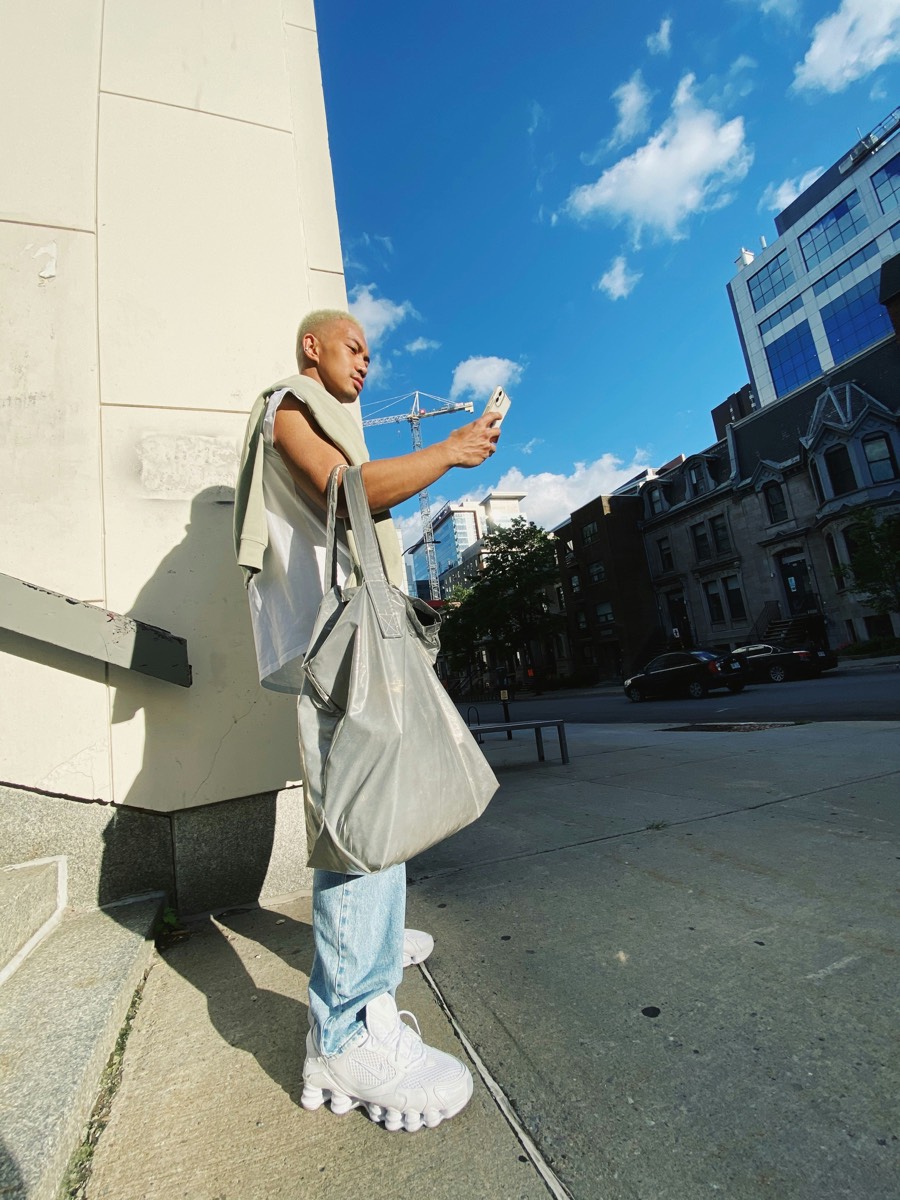Creator checking phone on a city street during a content shoot
